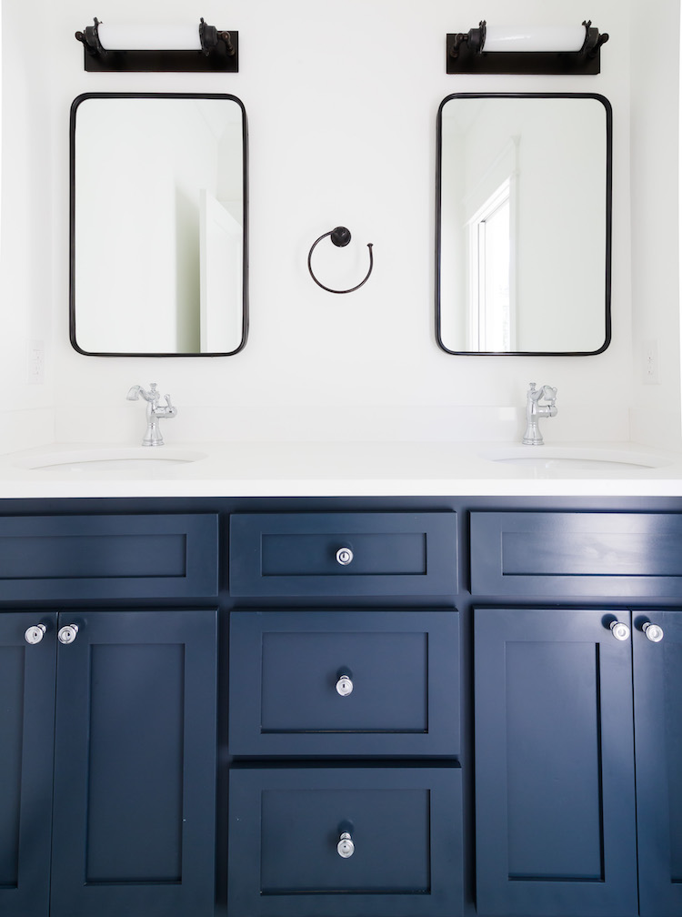 Benjamin Moore Blue Note Vanity- Mirrors by Rejuvenation, Sconces by RH - Guest Bathroom Design by Laura Design Co.